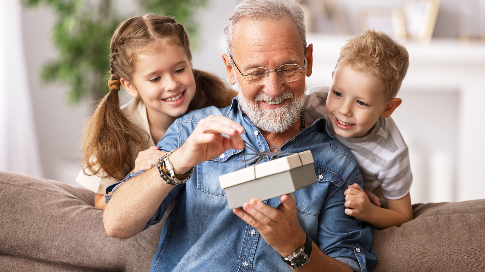 Bestefar öppnar gav och barnebarn som ser på