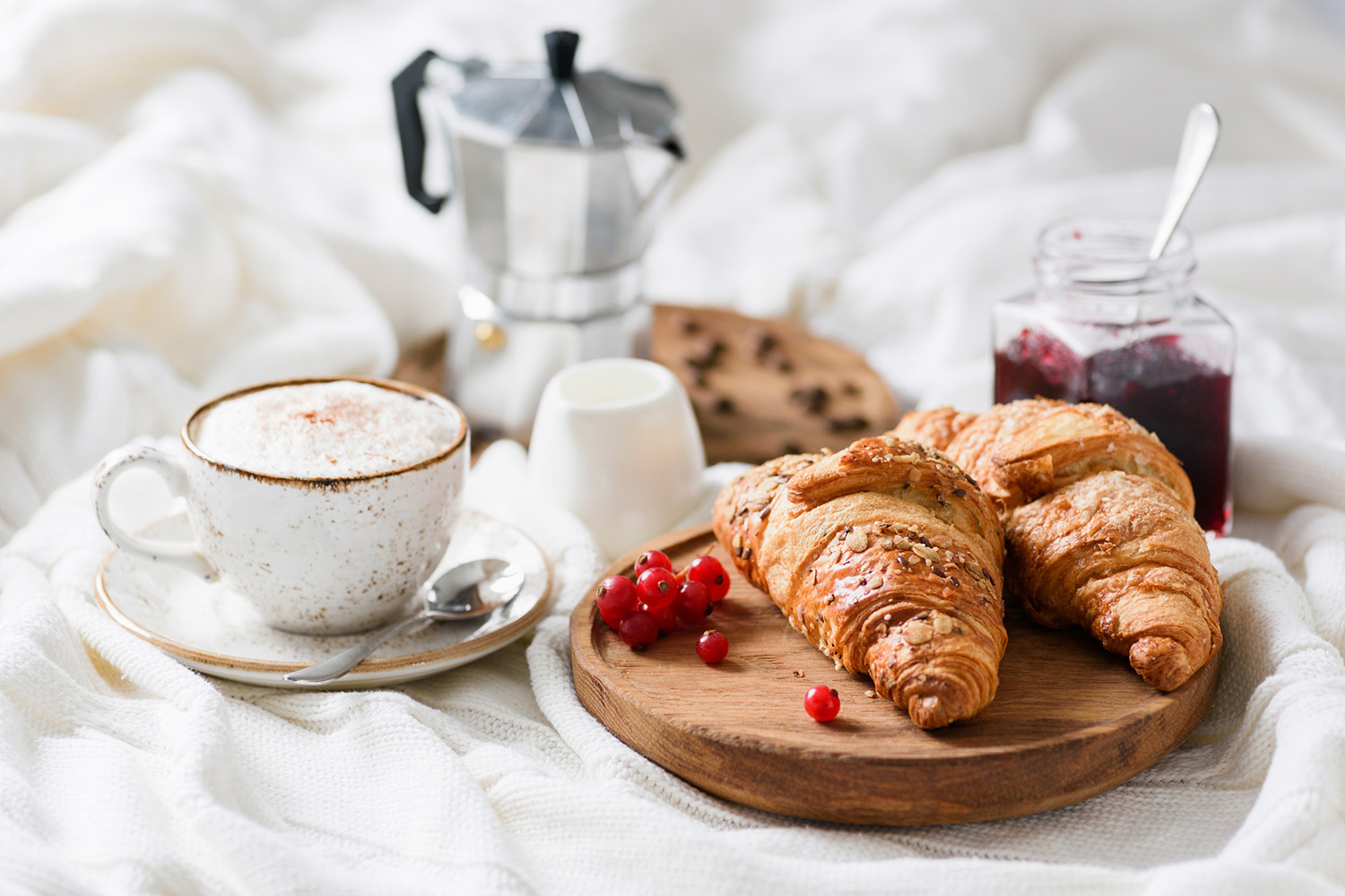Croissanter och kaffe på sängen - en utsökt frukost med varma bakverk och en rykande kopp kaffe