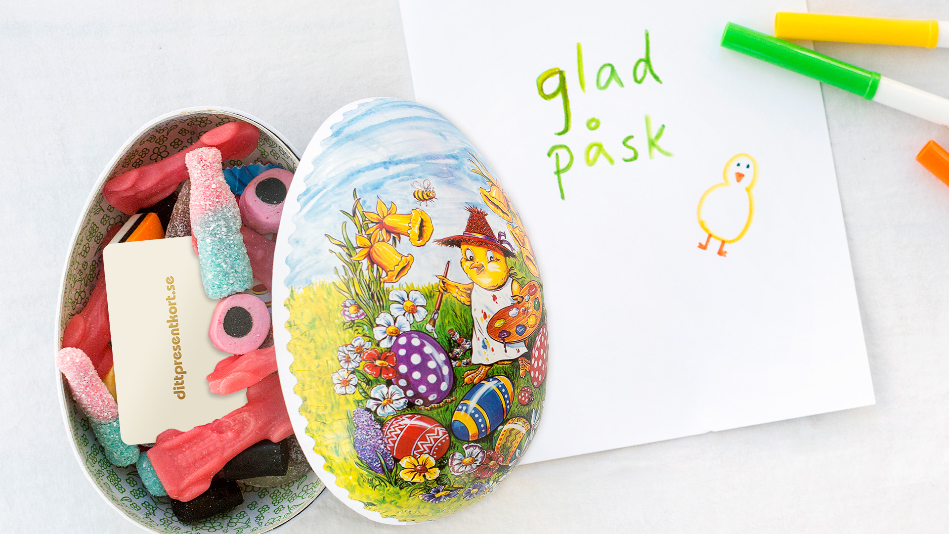 Påskägg fyllda med godis och ett presentkort intill ett papper med en liten hälsning. 